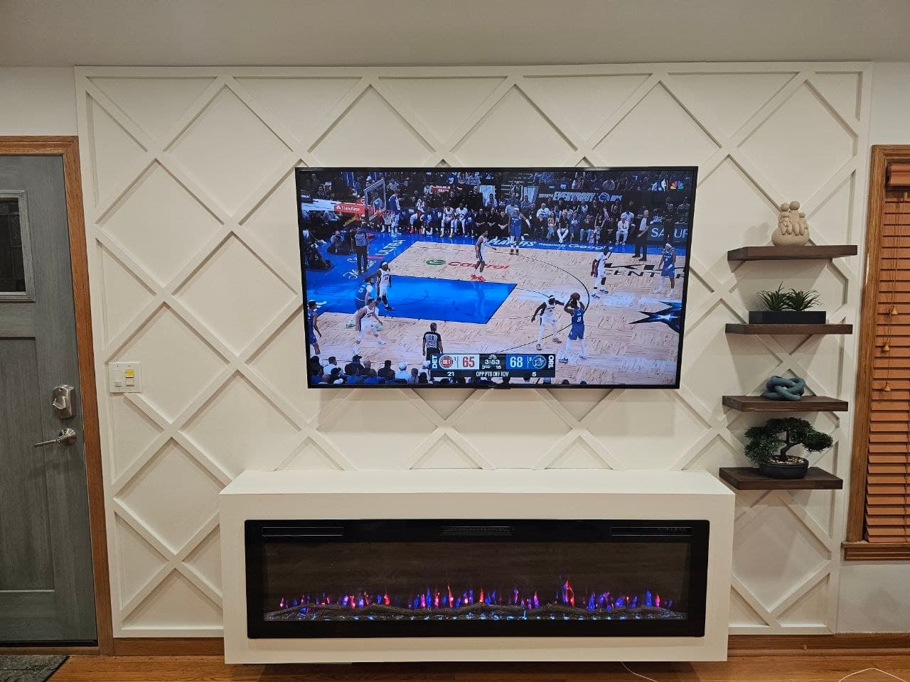 Close angle of a white diamond lattice media wall with mounted TV